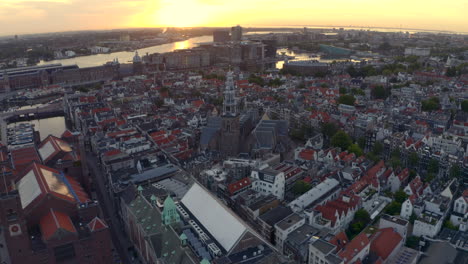 Niedrige-Drohnenaufnahmen-über-Der-Kirche-De-Oude-Kerk-Im-Zentrum-Von-Amsterdam-Bei-Sonnenaufgang