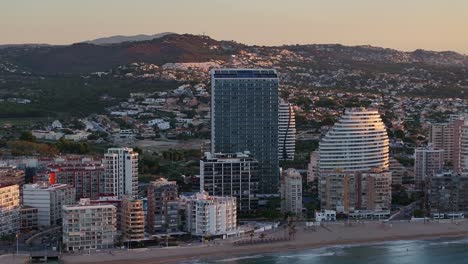 amazing aerial view about coastal cityscape of calp under evening light with distant mountains and local estimar hotels, alicante, spain