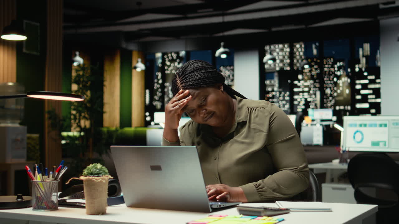 Troubled overworked woman sighing after realizing the late hour