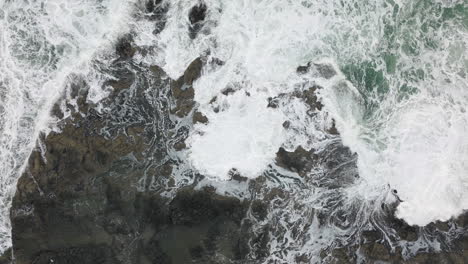 dangerous powerful churning waves spread whitewash water across thor's well, oregon coast, drone top down overview