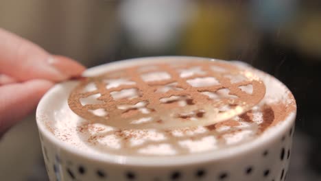 sprinkling chocolate powder on the coffee