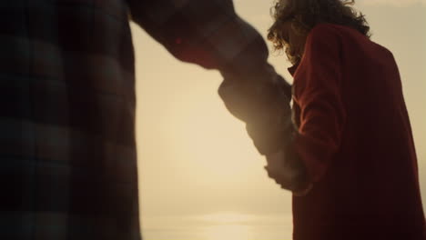 Couple-holding-hands-sunrise-beach.-Happy-girl-and-guy-enjoying-honeymoon