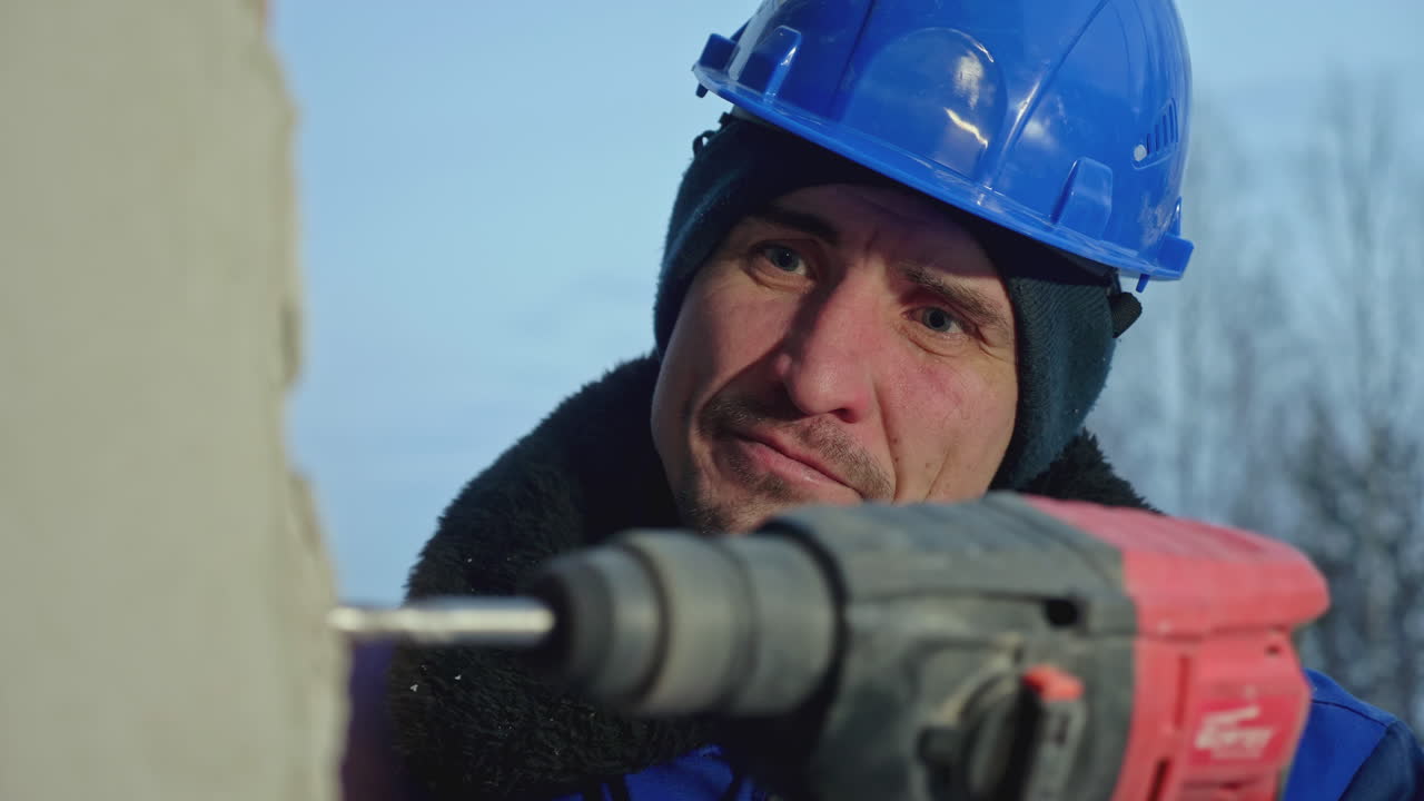 겨울에 잭햄머를 사용하는 건설 노동자