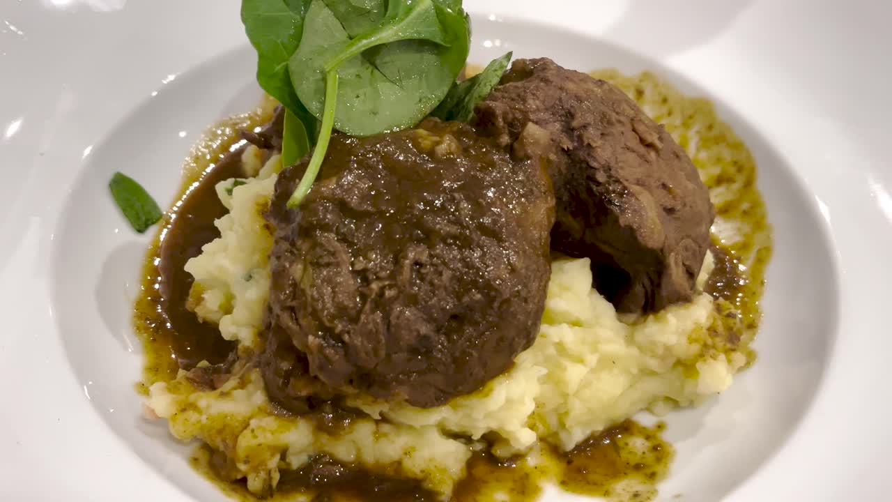 Tender beef tenderloin served with creamy mashed potatoes and a rich savory sauce, topped with fresh greens. A classic, comforting dish perfect for gourmet dining and special occasions.