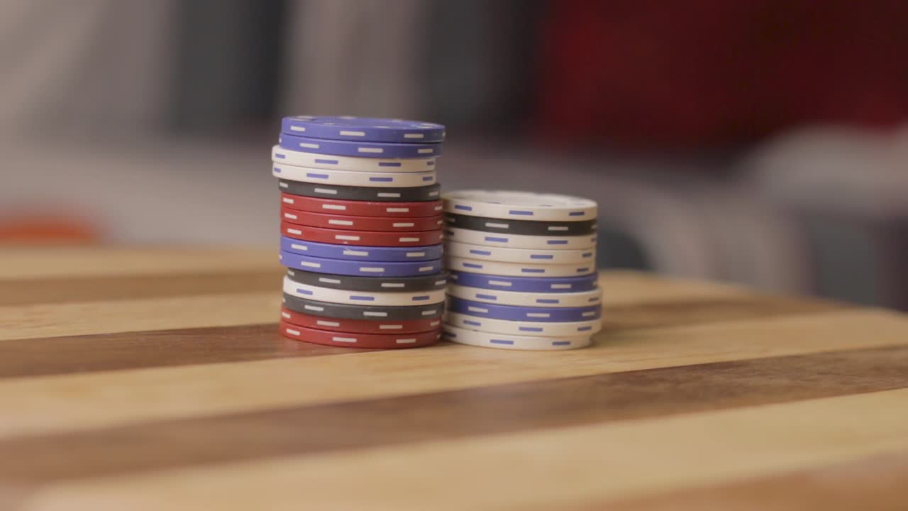 Fermo immagine di un uomo che spinge una pila di fiches da poker verso un'altra pila.