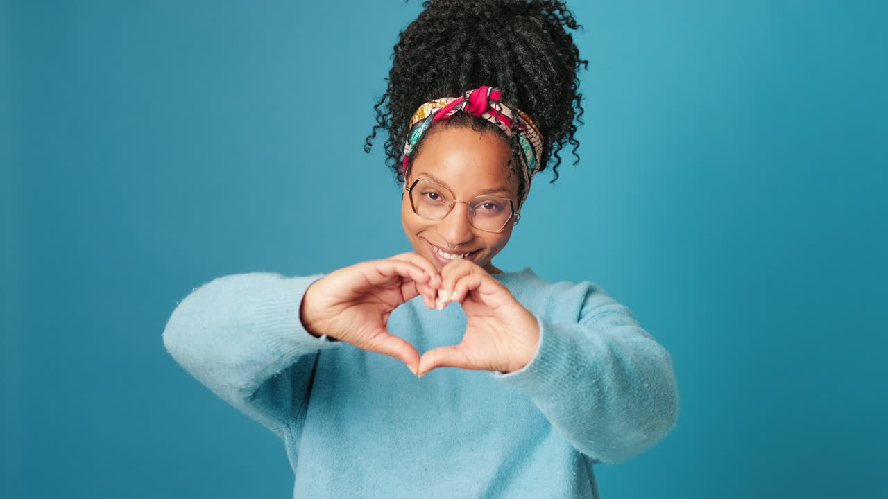 Happy Young Woman Making Heart Shape with Hands