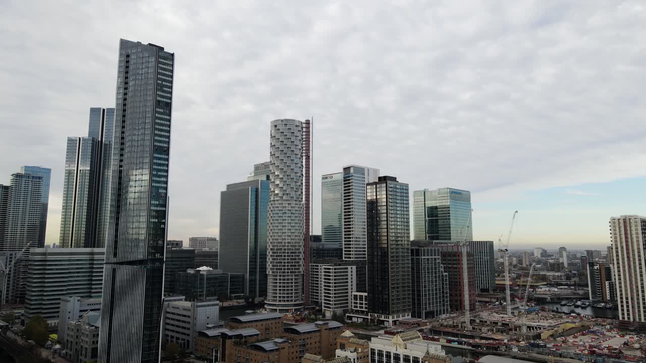 ascenso aéreo: hermoso y moderno horizonte londinense en el distrito de canary wharf durante el día soleado y nublado