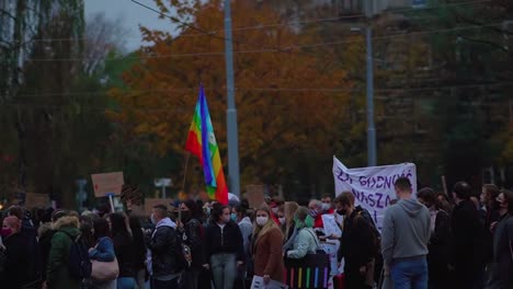 hundreds of polish activists hold flags and placards walking at street as they protest against the total abortion ban in poland amidst the covid-19. - wide shot