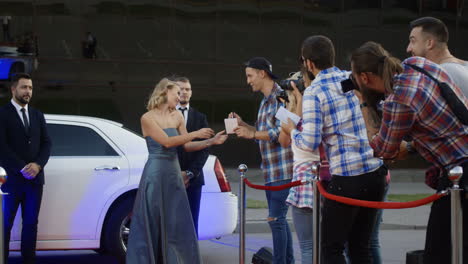 celebrity interacting with paparazzi and fans on a red carpet