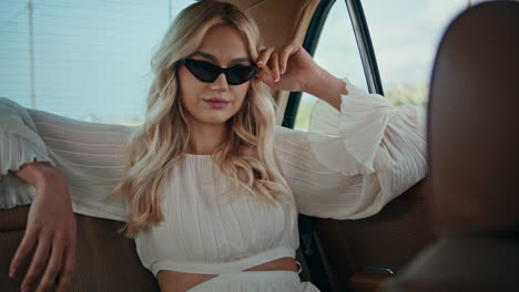 luxury woman passenger sitting on car back seat. girl looking automobile window.