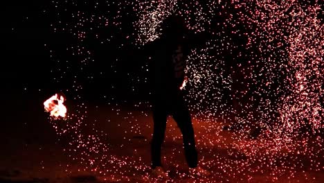 el artista muestra el arte del fuego en la playa.