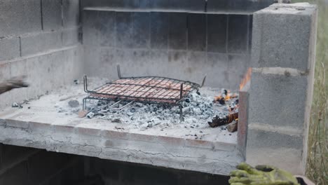sausages cooking on an outdoor grill over fire and coals