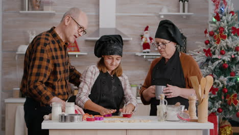 Grandchild-showing-to-grandparents-how-using-cookies-shape