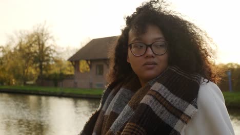 foto de retrato de una hermosa mujer negra parada frente al canal durante la hora dorada