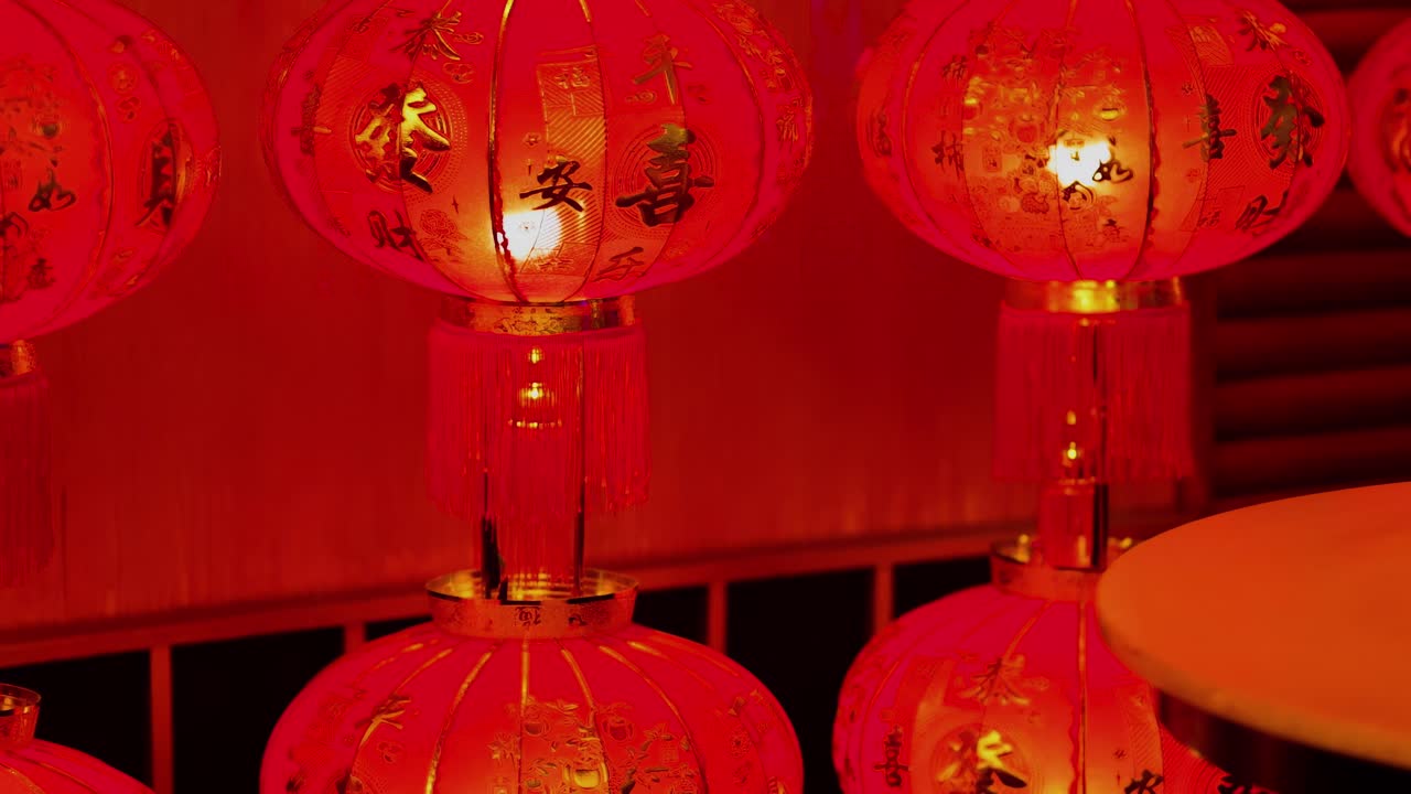 A series of red lanterns illuminate wooden stools, creating a warm and inviting atmosphere.