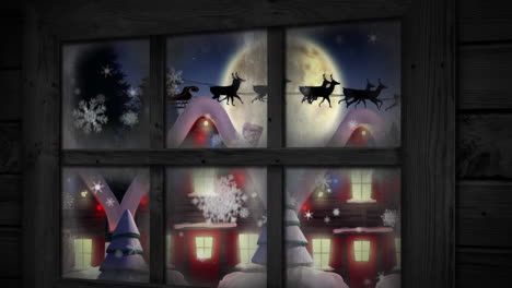 wooden window frame against snowflakes falling over multiple houses and trees on winter landscape