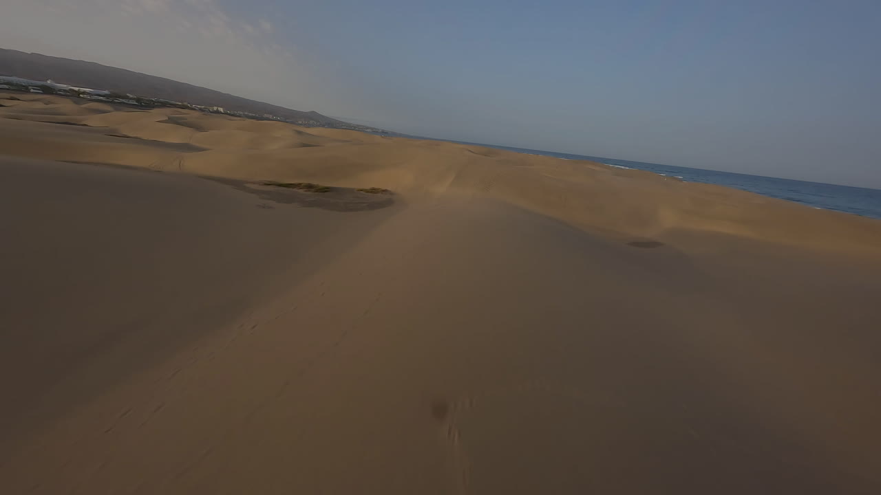 полет самолета над песчаными дюнами в маспаломасе на красивом закате