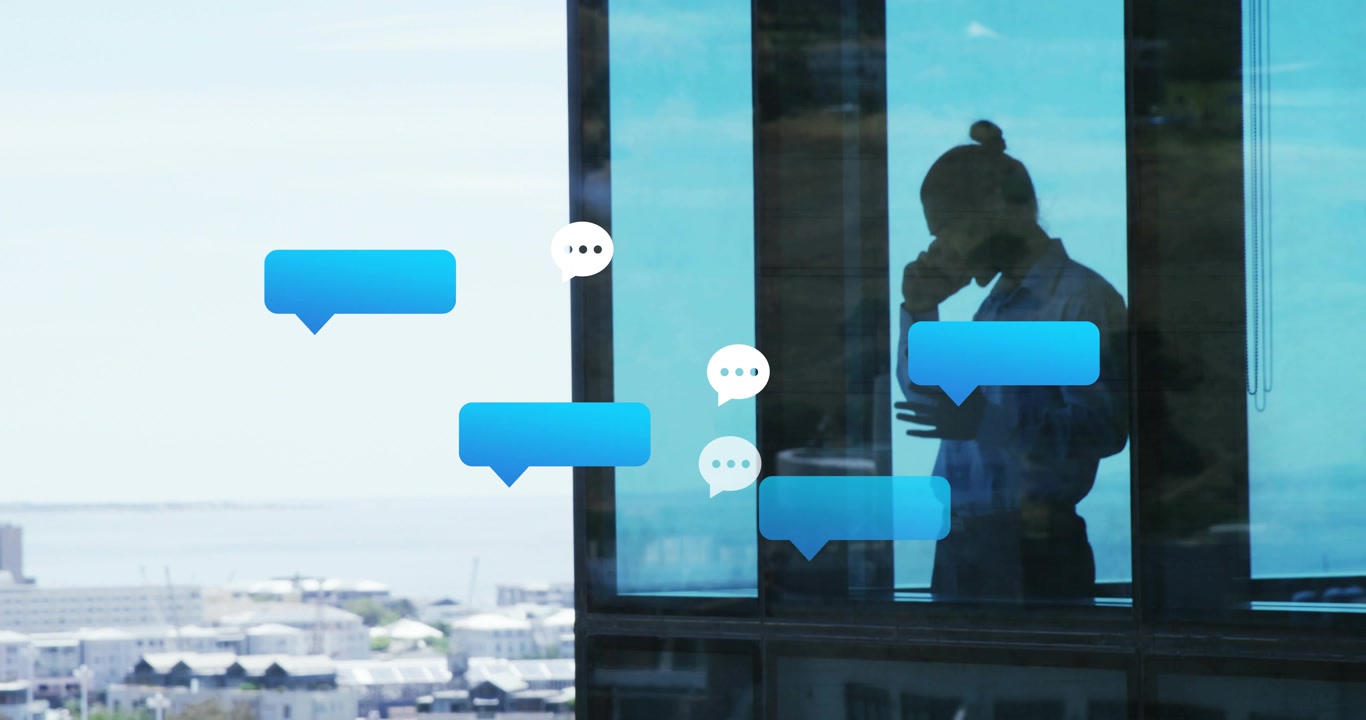 Business man lifting smartphone calling by window overlooking cityscape with floating chat bubbles