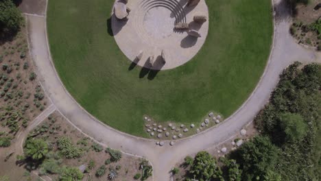 Circle-of-large-stones-placed-on-top-of-each-other-in-a-stone-park---top-down-reveal-shot