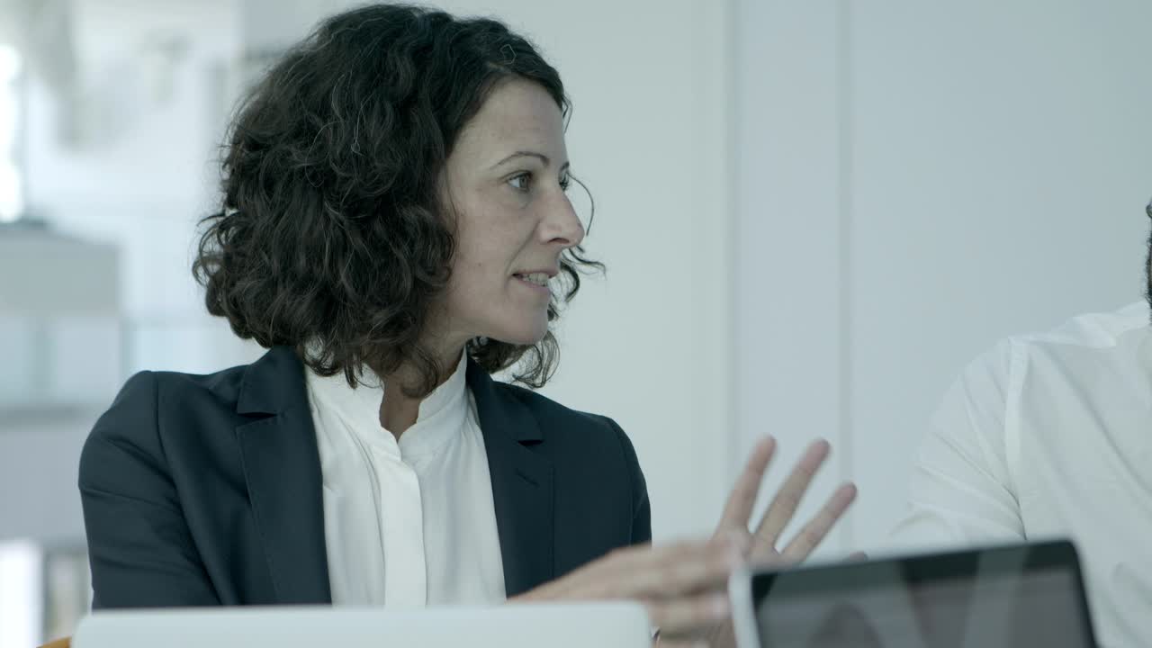 mujer de negocios sentada y hablando en la oficina