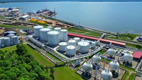 Aerial-drone-top-down-shot-over-oil-storage-tank-along-the-seaside-in-Paldiski,-Harju-County,-Estonia-on-a-sunny-day