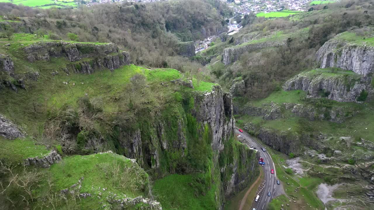 Forward-moving drone shot revealing Cheddar Gorge cliffs and road in deep focus.
