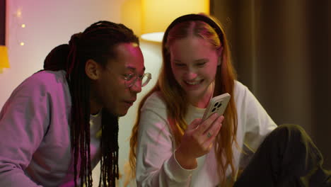 una pareja feliz mirando un teléfono juntos