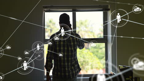 networking icons and connections animation over man standing by window