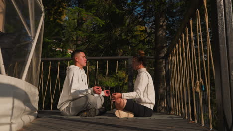 partners finds solace in lap of glamping luxury. young man and woman conscientiously engage in yoga techniques within eco retreat nurturing environment