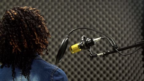 african american alfro hair black woman sing a song loudly and express feeling with power sound over hanging microphone condenser