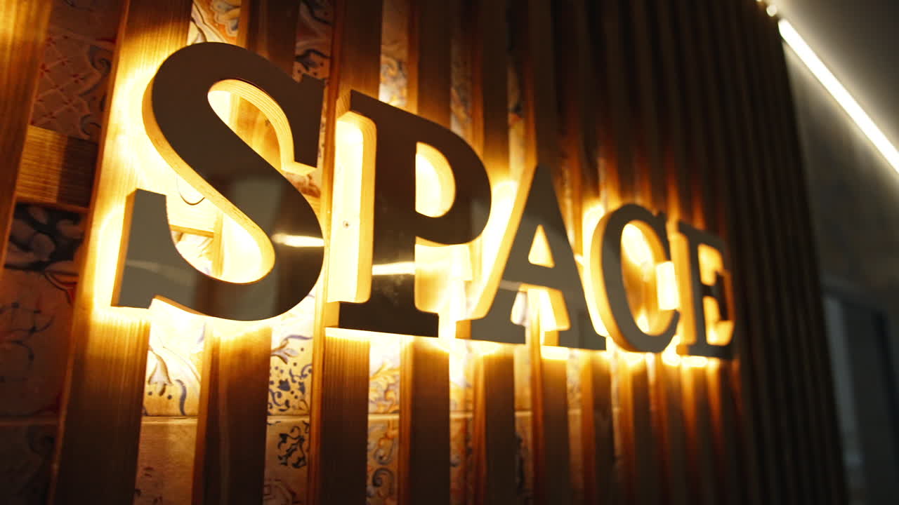 Bright signboard on the wooden planks on the wall. Footage along the letters naming the spa resort place. Close up.