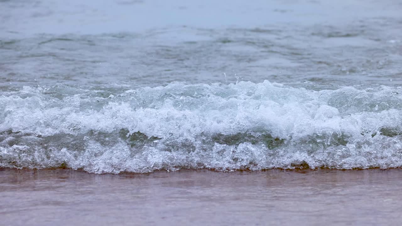 부드러운 파도가 모래 해변에 굴러
