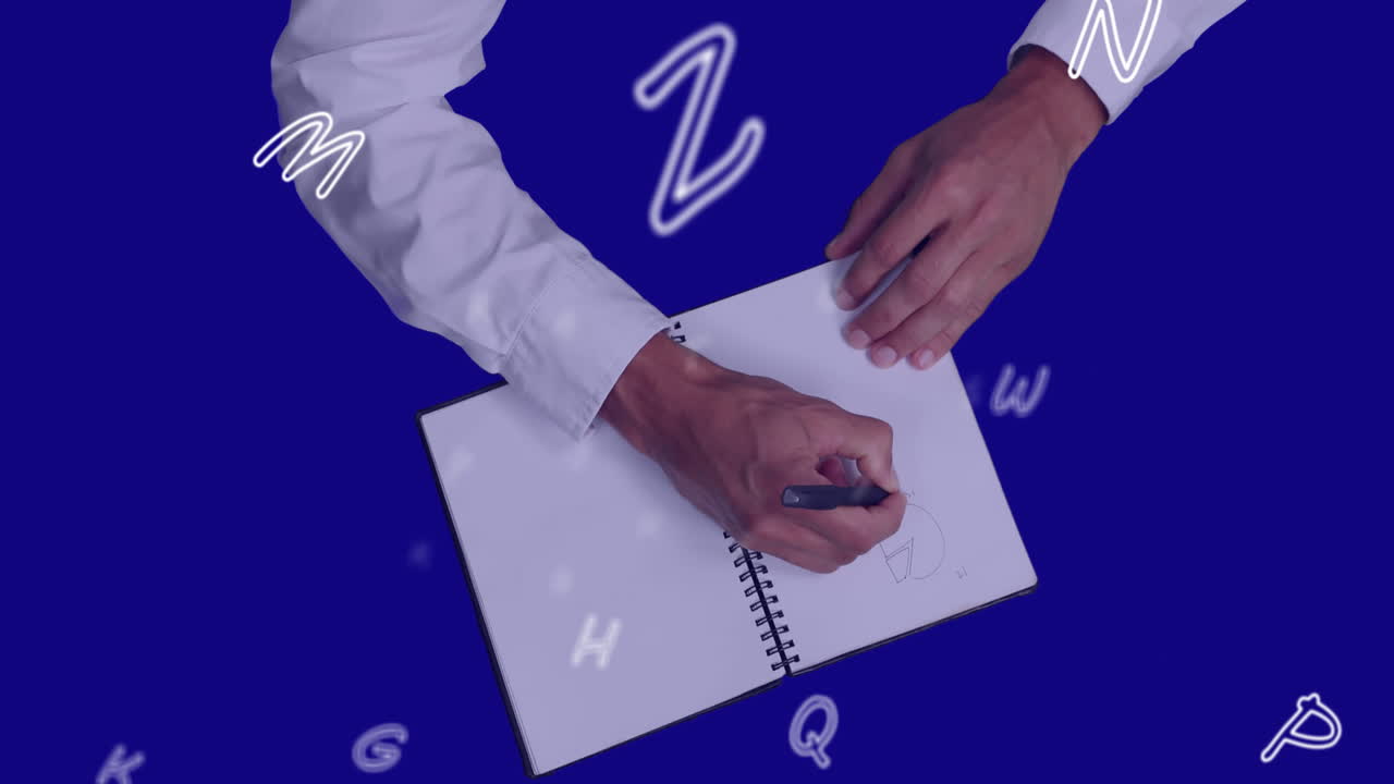 Animation of flying letters over person writing in notebook
