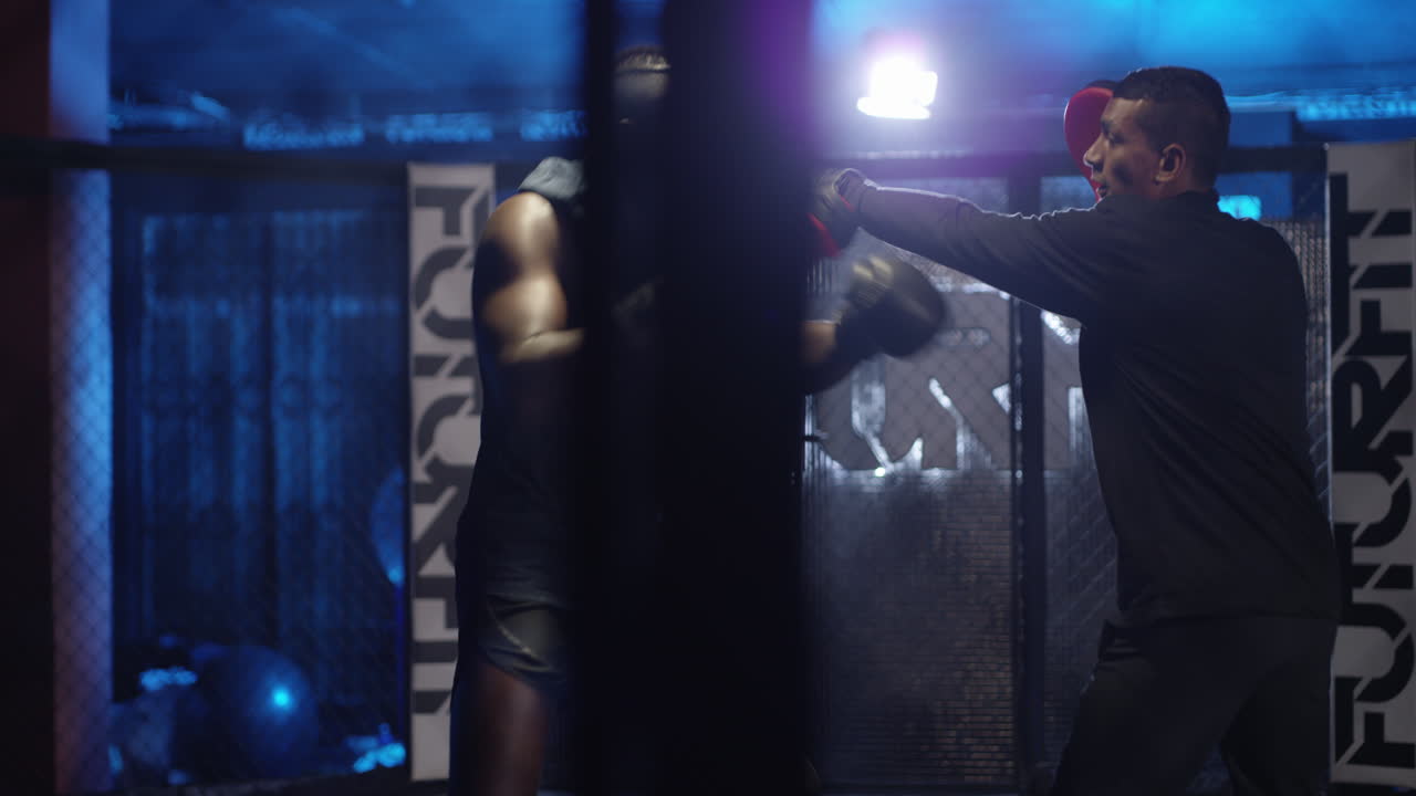 un joven practicando con su entrenador en un boxeo