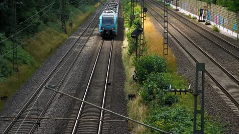 Eine-Nahaufnahme-Des-Daches-Eines-Blauen-Zuges-Ist-Zu-Sehen,-Wenn-Er-Schnell-Darunter-Hindurchfährt