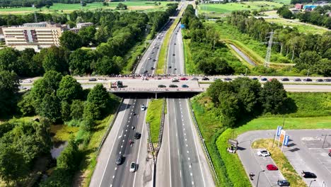 highway with a pedestrian bridge and crowd