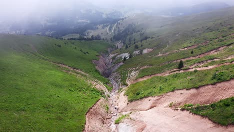 flying through clouds and mist above mountain canyon among green hills