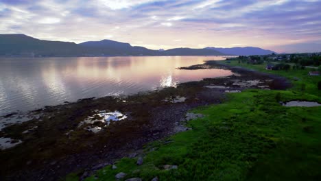 Drone-reflective-orange-lake-mountain-background-Sunset-green-Norwegian-farmland