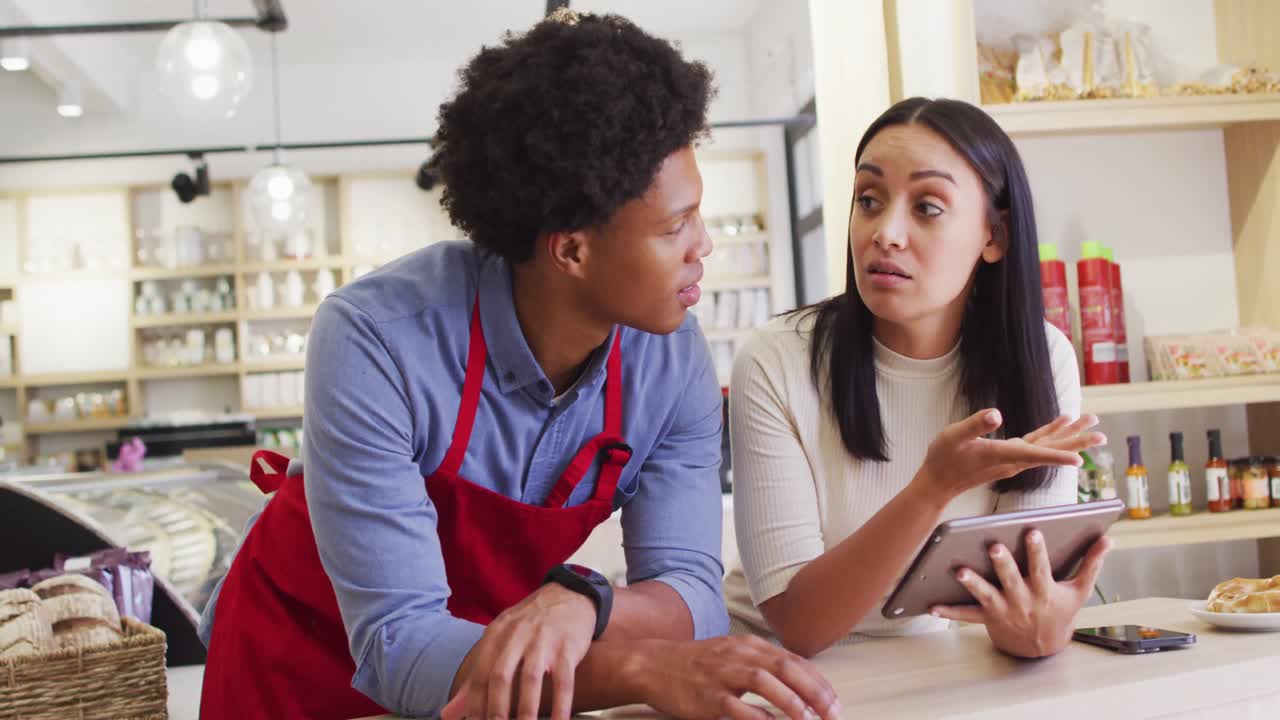 video de una mujer propietaria y un camarero trabajando con una cafetería en tabletat