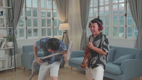 young asian father and his son have fun singing together at living room