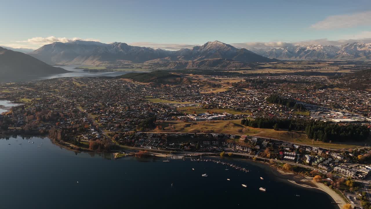Stunning 4K 60fps aerial drone footage reveals Wanaka town and Lake Wanaka at sunset. This cinematic clip is ideal for projects about travel, tourism, and the beautiful nature of New Zealand