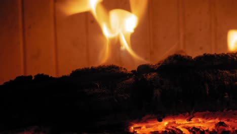 llama ardiente en la chimenea en troncos de madera