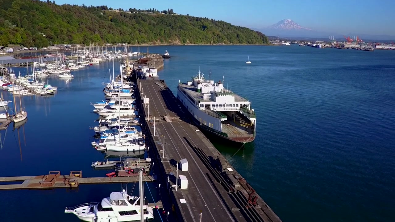 Aerial, reverse, drone shot tilting away from a abandoned ferry, at a harbor, sunny day, in Washington state, USA