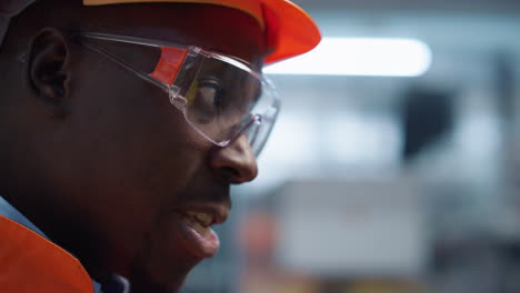 american supervisor talking at manufacturing factory closeup. uniformed engineer