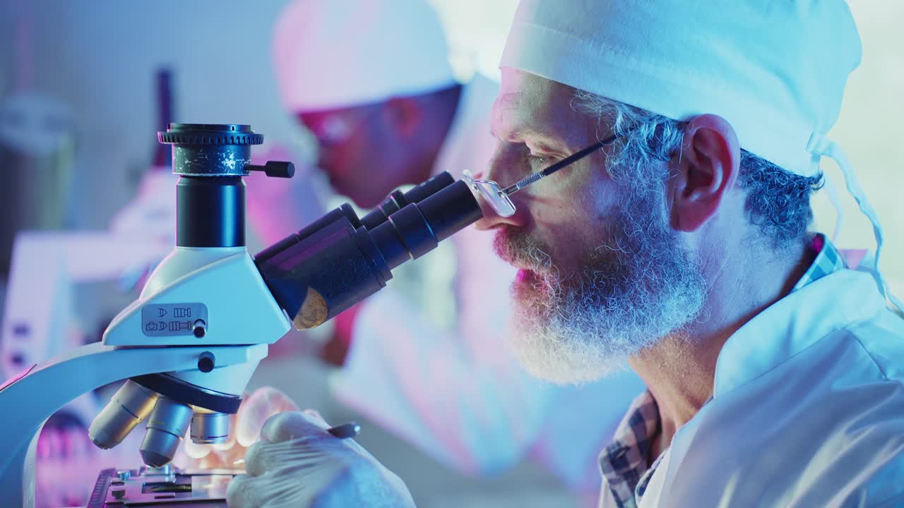 Focused Scientist Examining Samples with a Microscope