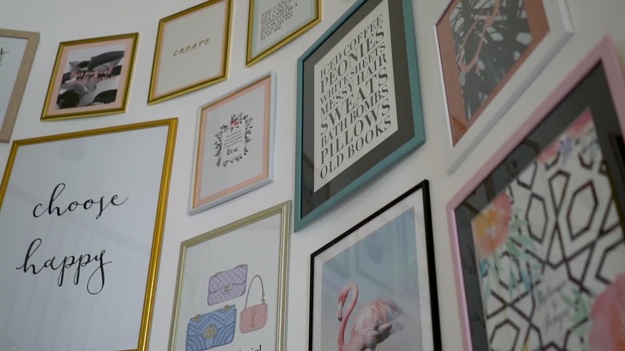 arte decorativo y marcos de citas colgados en la pared por la escalera curva en un restaurante vegano en dubai, eau - concepto de interior moderno - toma de panorámica inclinada hacia arriba