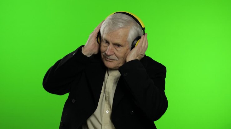 Anziano nonno caucasico balla, festeggia, ascolta musica. Sfondo chroma key.