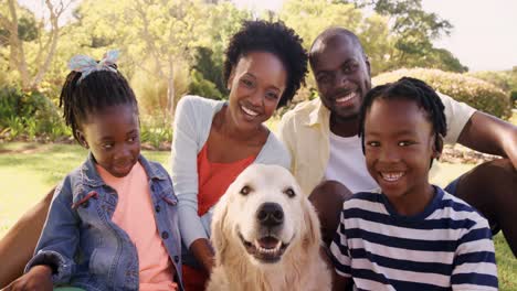 Portrait-of-cute-family-is-smiling-and-sitting-with-a-dog-