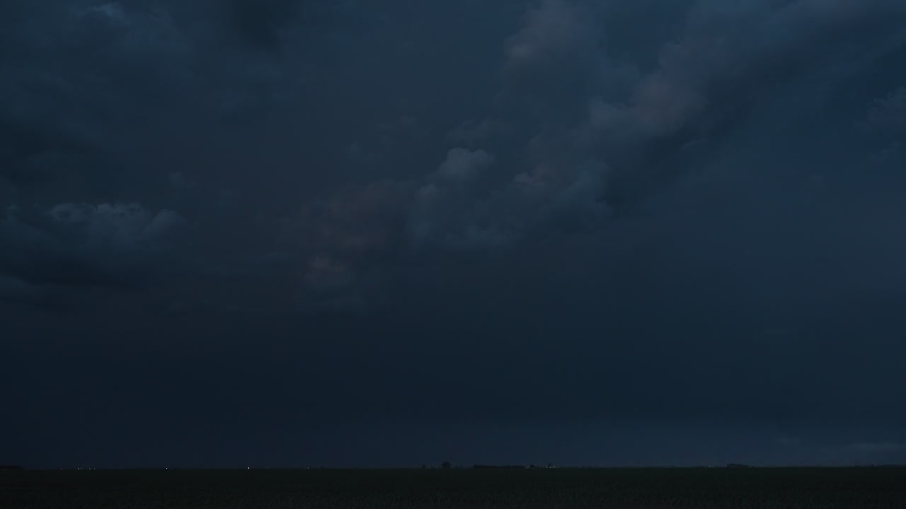 Quick flashes of lightning from a powerful thunderstorm light up the night sky