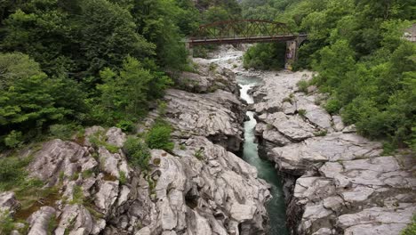 Rocky-gorge-with-river-and-bridge-in-Maggiatal-Vallemaggia,-Ticino,-Switzerland